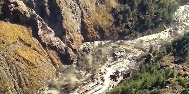 This frame grab from video provided by KK Productions shows a massive flood of water, mud and debris flowing at Chamoli District after a portion of Nanda Devi glacier broke off in Tapovan area of the northern state of Uttarakhand, India, Sunday, Feb.7, 2021. (KK Productions via AP)