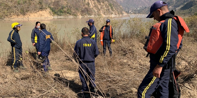 Rescuers prepare to search for bodies in the downstream of Alaknanda River in Rudraprayag, northern state of Uttarakhand, India, Monday, Feb.8, 2021. More than 2,000 members of the military, paramilitary groups and police have been taking part in search-and-rescue operations after part of a Himalayan glacier broke off Sunday and sent a wall of water and debris rushing down the mountain. (AP Photo/Rishabh R. Jain)