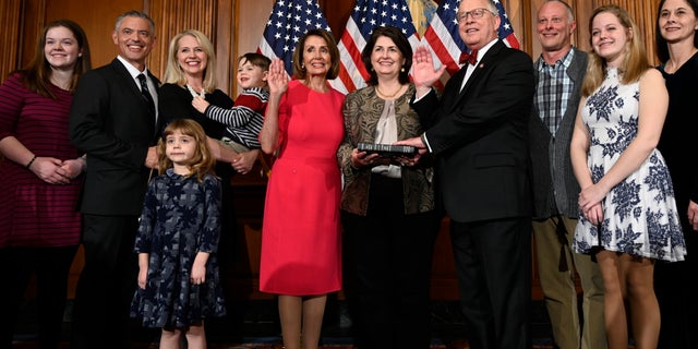 In this Jan. 3, 2019 file photo, House Speaker Nancy Pelosi of Calif., poses during a ceremonial swearing-in with Rep. Ron Wright, R-Texas, fourth from right, on Capitol Hill in Washington during the opening session of the 116th Congress. (AP Photo/Susan Walsh, File)