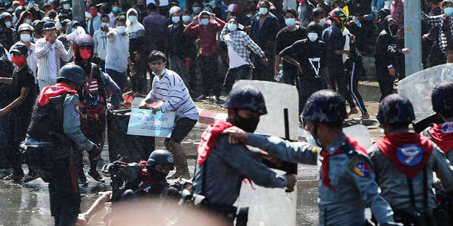 Protesters run after police fire warning-shots and use water cannons to disperse them during a protest in Mandalay, Burma on Tuesday, Feb. 9, 2021. Police cracked down Tuesday on the demonstrators protesting against Burma’s military takeover who took to the streets in defiance of new protest bans. (AP Photo)