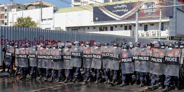 Police in riot gear march to take a position to block demonstrators at an intersection during a protest in Mandalay, Burma, Tuesday, Feb. 9, 2021. Police were cracking down on the demonstrators against Burma’s military takeover who took to the streets in defiance of new protest bans. (AP Photo)