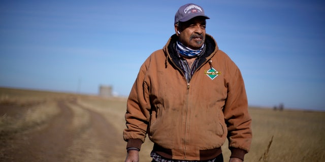 In this Jan. 13, 2021, file photo, Rod Bradshaw stands in a field of wheat on his farm near Jetmore, Kan. (AP Photo/Charlie Riedel File)
