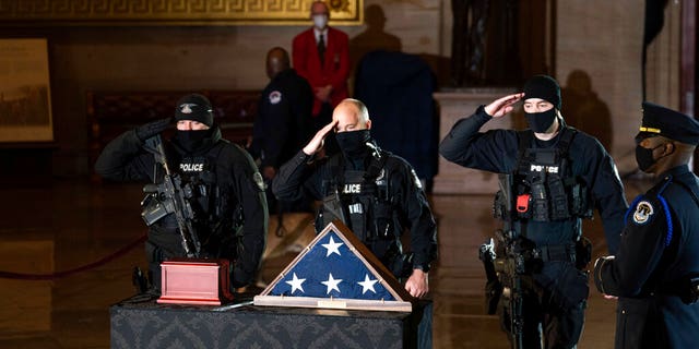 DOSSIER: Les officiers de la police du Capitole rendent hommage au regretté officier de police du Capitole américain Brian Sicknick alors qu'une urne avec sa dépouille incinérée repose en honneur sur une table drapée de noir au centre de la rotonde du Capitole à Washington.