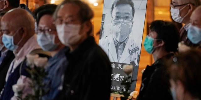 FILE - In this Feb. 7, 2020 file photo, people wearing masks attend a vigil for Chinese doctor Li Wenliang, in Hong Kong. The outpouring of grief and rage sparked by Li's death was an unusual - and for the Chinese Communist Party, unsettling - display in China's tightly monitored civic space. (AP Photo/Kin Cheung, File)