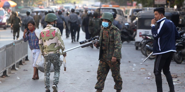 A soldier holds a long firearm during a crackdown on anti-coup protesters holding a rally in front of the Myanmar Economic Bank in Mandalay, Burma on Monday, Feb. 15, 2021. (AP Photo)