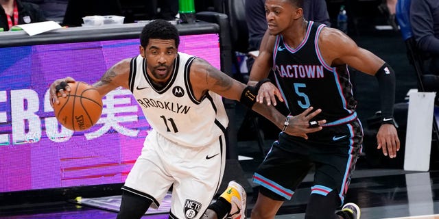 Brooklyn Nets Guard Kyrie Irving, links, fährt während der ersten Hälfte eines NBA-Basketballspiels in Sacramento, Kalifornien, Montag, 15. Februar 2021, gegen Sacramento Kings Guard De'Aaron Fox. (AP Photo/Rich Pedroncelli)