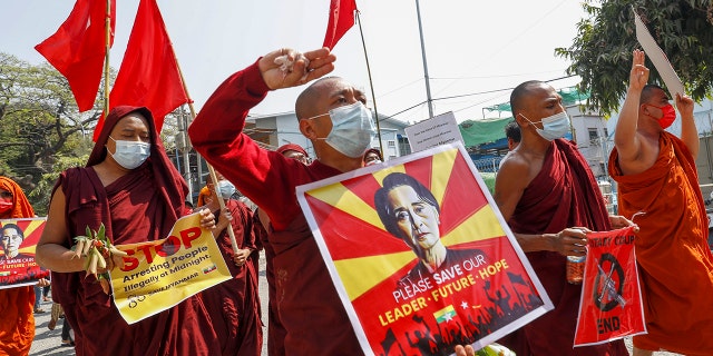 Buddhist monks and nuns display pictures of detained Burma leader Aung San Suu Kyi during a protest against the military coup in Mandalay, Myanmar on Tuesday, Feb. 16, 2021. (AP Photo)