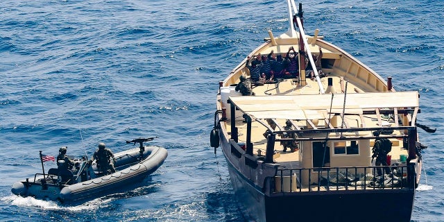 In this Friday, Feb. 12, 2021 photo released by the U.S. Navy, the guided-missile destroyer USS Winston S. Churchill boarded a stateless dhow off the coast of Somalia and interdicted an illicit shipment of weapons and weapon components. The U.S. Navy said on Tuesday, Feb. 16, that it seized a large cache of weapons, including Kalashnikov-style rifles and rocket-propelled grenade launchers, being smuggled by ships off the coast of Somalia. (Mass Communication Specialist 3rd Class Louis Thompson Staats IV/U.S. Navy via AP)