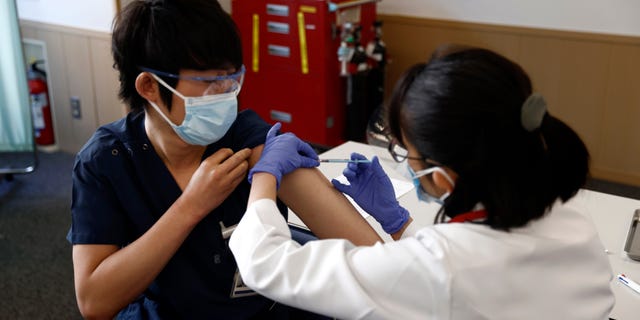 Um trabalhador médico recebe uma dose da vacina COVID-19 no Tokyo Medical Center em Tóquio na quarta-feira, 17 de fevereiro de 2021. (Behrouz Mehri / Foto da piscina via AP)