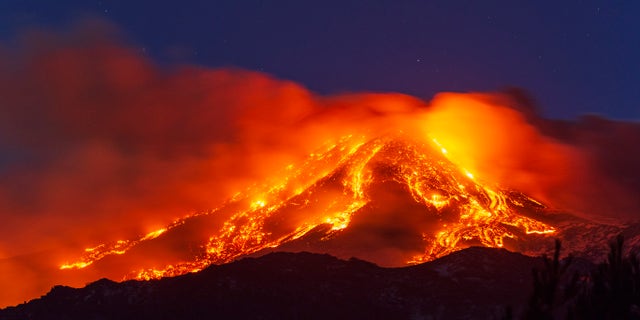 Lava gushes from the Mt Etna volcano near Catania, Sicily, Tuesday, Feb. 16, 2021. Europe's most active volcano came alive around 4 pm local time on Tuesday, according to the Italian Institute of Geophysics and Volcanology. (AP Photo/Salvatore Allegra)