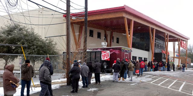 People line up outside an HEB grocery store in the snow Thursday, February 18, 2021, in Austin, Texas. 