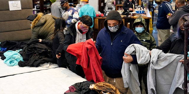 People select shirts and sweatshirts being given away at a Gallery Furniture store after the owner opened his business as a shelter for those without power at their homes in Houston, Feb. 16, 2021. (Associated Press)