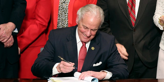 South Carolina Gov. Henry McMaster signs into law a bill banning almost all abortions in the state Thursday, Feb. 18, 2021, in Columbia, S.C. On the same day, Planned Parenthood filed a federal lawsuit to stop the measure from going into effect.  The state House approved the "South Carolina Fetal Heartbeat and Protection from Abortion Act" on a 79-35 vote Wednesday and gave it a final procedural vote Thursday before sending it to McMaster.  (AP Photo/Jeffrey Collins)