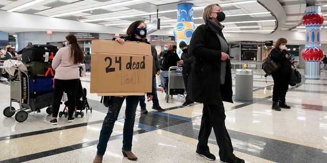 Mary Kay Hoffman, left, and Cindy Durham, right, wait for the arrival of Sen. Ted Cruz, R-Texas, at the international arrivals terminal at George Bush Intercontinental Airport Thursday, Feb. 18, 2021, in Houston. (AP Photo/David J. Phillip)