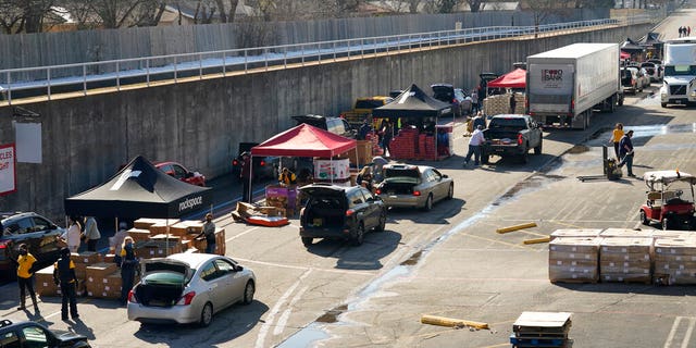 Volunteers distribute food and water at a San Antonio Food Bank drive-thru food distribution site held at Rackspace Technology on Friday, February 19, 2021, in San Antonio.  (AP Photo / Eric Gay)