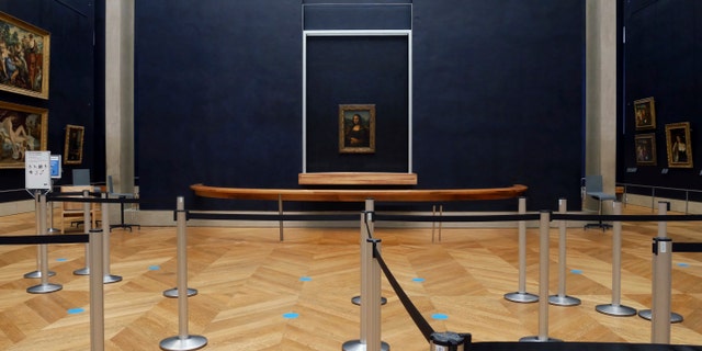 Leonardo da Vinci's Mona Lisa hangs on the wall in a deserted Louvre museum. (AP Photo/Thibault Camus)