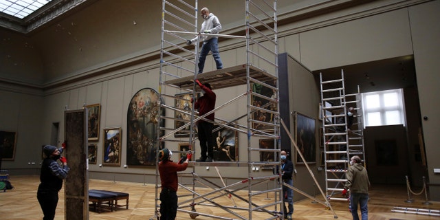 Workers at the Louvre museum set up scaffolding in the museum. (AP Photo/Thibault Camus)