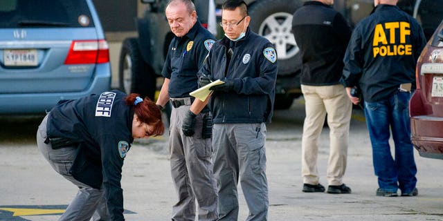Investigators look at evidence at the scene of a multiple fatality shooting at the Jefferson Gun Outlet in Metairie, La., on Saturday, Feb. 20, 2021. (Associated Press)