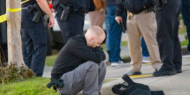 An unidentified man looks down scene of a multiple fatality shooting at the Jefferson Gun Outlet in Metairie, La. Saturday, Feb. 20, 2021. (Associated Press)