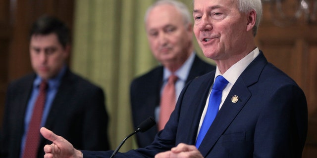 Governor Asa Hutchinson, right, speaks in Little Rock, Ark.  Hutchinson.  (Staton Breidenthal / The Arkansas Democrat-Gazette via AP, file)