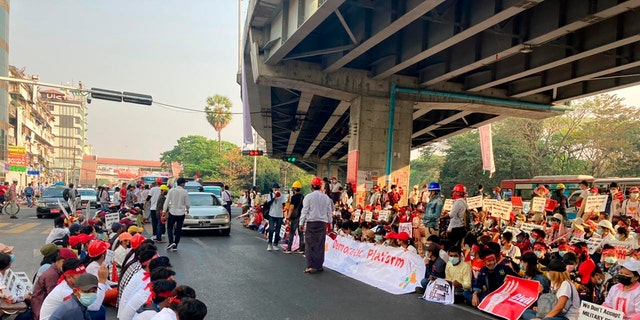 Anti-coup protesters gather under an elevated roadway just outside the Hledan Centre in Yangon, Burma Monday, Feb. 22, 2021. A call for a Monday general strike by demonstrators in Burma protesting the military's seizure of power has been met by the ruling junta with a thinly veiled threat to use lethal force, raising the possibility of major clashes. (AP Photos)