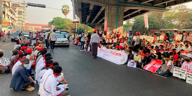 Anti-coup protesters gather under an elevated roadway just outside the Hledan Centre in Yangon, Burma Monday, Feb. 22, 2021. A call for a Monday general strike by demonstrators in Burma protesting the military's seizure of power has been met by the ruling junta with a thinly veiled threat to use lethal force, raising the possibility of major clashes. (AP Photos)