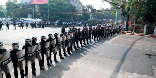 Police security forces form a line to block a road near the U.S. embassy in Yangon, Burma Monday, Feb. 22, 2021. Protesters gathered in Burma's biggest city Monday despite the ruling junta's thinly veiled threat to use lethal force if people answered a call for a general strike opposing the military takeover three weeks ago. (AP Photo)