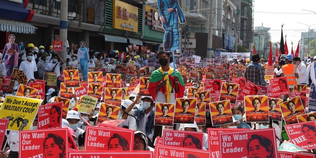 Anti-coup protesters hold up posters with images of deposed Burma leader Aung San Suu Kyi during a rally near the Mandalay Railway Station in Mandalay, Burma Monday, Feb. 22, 2021. A call for a Monday general strike by demonstrators in Burma protesting the military's seizure of power has been met by the ruling junta with a thinly veiled threat to use lethal force, raising the possibility of major clashes. (AP Photo)