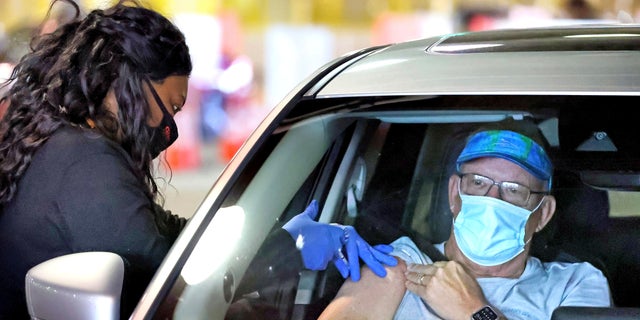 A Florida resident gets vaccinated at the Orange County Convention Center drive-thru site in Orlando, Monday, Feb. 22, 2021.