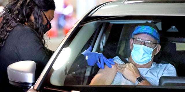 Un résident de Floride se fait vacciner sur le site de service au volant du Orange County Convention Center à Orlando, le lundi 22 février 2021 (Joe Burbank / Orlando Sentinel via AP)