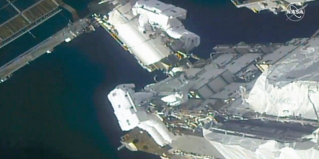 In this image from a NASA video, NASA astronauts Kate Rubins, top, and Victor Glover are working outside the International Space Station on Sunday, February 28, 2021. The space travel astronauts stand by ventured on Sunday to install support frames for new high-efficiency solar panels arriving at the International Space Station later this year.  (NASA via AP)