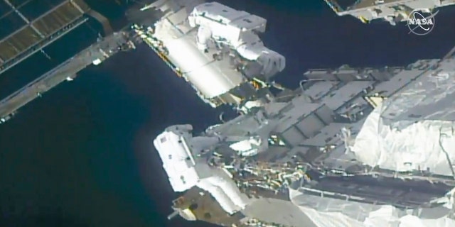 In this image taken from NASA video, NASA astronauts Kate Rubins, top, and Victor Glover work outside the International Space Station Sunday, Feb. 28, 2021. The spacewalking astronauts ventured out Sunday to install support frames for new, high-efficiency solar panels arriving at the International Space Station later this year. (NASA via AP)