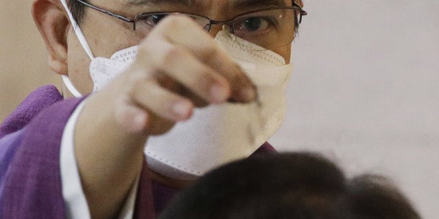 A Catholic priest sprinkles ash on the head of a man during Ash Wednesday rituals Feb 17, 2021, at the St. Gabriel the Archangel Parish in Caloocan, Metro Manila, Philippines. The parish distributed blessed ashes placed in small sachets to residents who cannot go to church so they can mark themselves and other family members at home to prevent the spread of COVID-19 virus. Ash Wednesday marks the start of lent in this largely Roman Catholic country. (AP Photo/Aaron Favila)