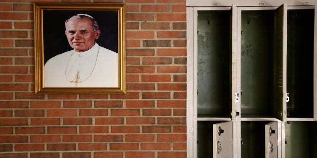 A portrait of St. John Paul II hangs beside a row of empty lockers in the main hallway of Quigley Catholic High School in Baden, Pa., in June 2020. (AP)