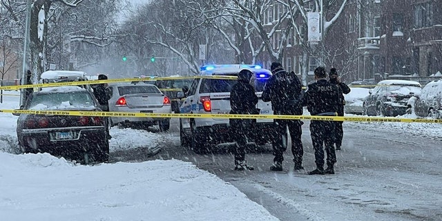Officers investigate a shooting in Chicago last month despite heavy snowfall impacting the city.