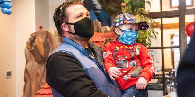 Christopher Milecki, 3, is carried into the Ronald McDonald House Charities Maryland headquarters by his father, Mark. (Olivia Bush Photography)