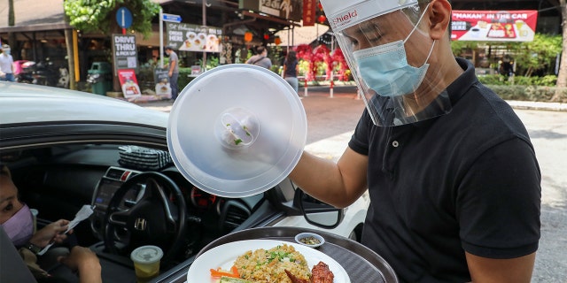 侍应生在Padi House餐厅外为顾客提供“车内用餐”服务。 (路透社/林惠腾)