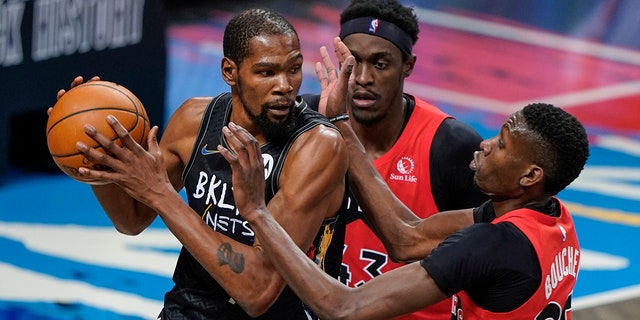 Toronto Raptors' Pascal Siakam (43) and Chris Boucher (25) defend against Brooklyn Nets' Kevin Durant (7) during the first half of an NBA basketball game Friday, Feb. 5, 2021, in Brooklyn, N.Y. (Associated Press)