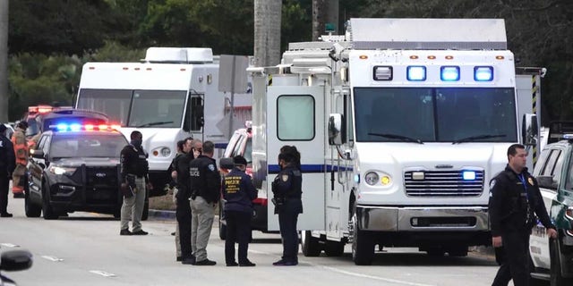 Law enforcement officials gather near the scene of a shooting that injured several FBI agents in Sunrise, Fla. On Tuesday, February 2, 2021 (Joe Cavaretta / South Florida Sun-Sentinel via AP)