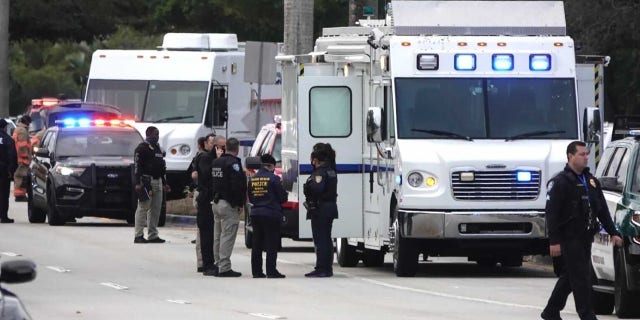 Law enforcement gathers near the scene of a shooting that wounded several FBI agents in Sunrise, Fla., Tuesday, Feb. 2, 2021. (Joe Cavaretta/South Florida Sun-Sentinel via AP)