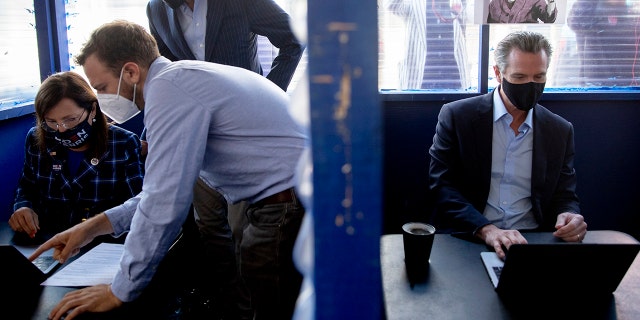 SAN FRANCISCO, CA - NOV. 3: Lieutenant Governor Eleni Kounalakis (left) and Governor Gavin Newsom sit in nearby booths outside of Manny's cafe and communal space in San Francisco, Calif. Tuesday, November 3, 2020 to phone bank for democratic candidates. (Jessica Christian/The San Francisco Chronicle via Getty Images)