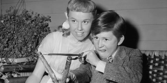 Doris Day watches Billy Gray with slingshot off-camera from the film 'On Moonlight Bay', 1951.