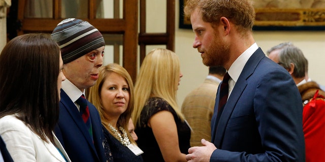 Prince Harry talks to Martyn Compton, a former British soldier from the Cavalry Regiment of the Household who was injured after an RPG set his vehicle on fire in Afghanistan during Lord Curry's Big Curry Lunch in aid of the ABF The Soldiers Charity in The Guildhall on April.  7, 2016, in London, England.