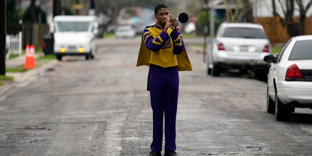 Elvin King III, a senior at Warren Easton High and member of their marching band which was slated to perform in a now-canceled parade, poses for a portrait in front of his home in New Orleans. (AP Photo/Gerald Herbert)