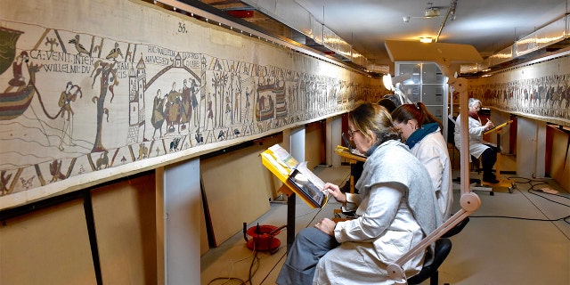 This photo provided by Bayeux townhall shows technicians working at the tapestry in Bayeux, Normandy on Jan. 8 2020. (Ville de Bayeux via AP)