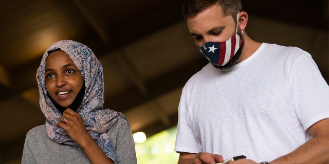 Rep. Ilhan Omar [D-MN) (C) campaigns with her husband Tim Mynett (R) at the Richfield Farmers Market on August 8, 2020 in Richfield, Minnesota.(Photo by Stephen Maturen/Getty Images)