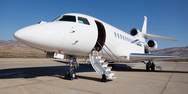 A stock image of a private jet parked on an airport tarmac.