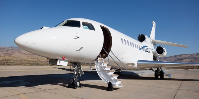 A stock image of a private jet parked on an airport tarmac.