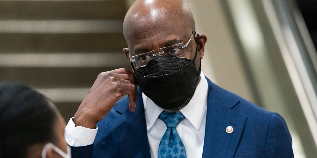 Sen. Raphael Warnock, D-Ga., right, talks to a reporter as he leaves the Capitol at the conclusion of the second day of the second impeachment trial of former President Donald Trump, on Capitol Hill in Washington, Wednesday, Feb. 10, 2021. (AP Photo/Manuel Balce Ceneta)