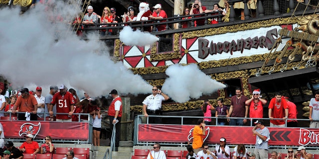 Fans cover their ears as cannons fire from the pirate ship at Raymond James Stadium during a NFL football game between the Tampa Bay Buccaneers and the New York Jets Sunday, Dec. 13, 2009 in Tampa, Fla. (WHD Photo/Steve Nesius)